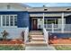 Inviting front porch with stone steps and white railings, enhancing the home's curb appeal at 6110 N Suwanee Ave, Tampa, FL 33604