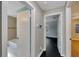 Hallway featuring bathroom and bedroom entryways, painted walls, and dark flooring at 6110 N Suwanee Ave, Tampa, FL 33604