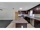 Modern kitchen with granite countertops, island, stainless steel appliances, and dark wood cabinets at 6110 N Suwanee Ave, Tampa, FL 33604