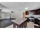 Bright, open-concept kitchen with a granite island, stainless steel appliances, and dark wood cabinets at 6110 N Suwanee Ave, Tampa, FL 33604