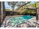 A screened-in pool area offers a refreshing retreat with a inflatable shark toy floating in the crystal clear water at 6110 N Suwanee Ave, Tampa, FL 33604