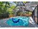A screened-in pool and patio featuring a playful blue shark float, perfect for relaxation and summer fun at 6110 N Suwanee Ave, Tampa, FL 33604