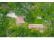 Aerial view of a home with a red tile roof, surrounded by lush greenery and mature trees at 6234 Neff Lake Rd, Brooksville, FL 34601