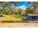 A large grassy backyard with an outbuilding and covered structure at 6234 Neff Lake Rd, Brooksville, FL 34601