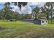 A long outbuilding with a red roof and view of the green backyard at 6234 Neff Lake Rd, Brooksville, FL 34601