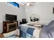 Comfortable bedroom featuring a faux fireplace, television, ceiling fan, and round mirror on the dresser at 6420 92Nd N Pl # 1205, Pinellas Park, FL 33782