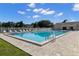Refreshing community pool surrounded by plenty of lounge chairs with a clear blue sky at 6420 92Nd N Pl # 1205, Pinellas Park, FL 33782