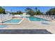 Community pool, hot tub, and lounge chairs surrounded by a gated fence at 6420 92Nd N Pl # 1205, Pinellas Park, FL 33782