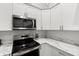Kitchen featuring stainless steel appliances, white cabinets, and marble countertops at 6420 92Nd N Pl # 1205, Pinellas Park, FL 33782