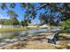 Scenic community pond with a bench overlooking the water and mature trees at 6420 92Nd N Pl # 1205, Pinellas Park, FL 33782