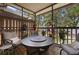 Relaxing screened in porch with cushioned seating, fan, round table, and plant decor at 6420 92Nd N Pl # 1205, Pinellas Park, FL 33782
