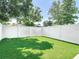 Private backyard featuring vibrant artificial turf and a tall white fence for enhanced seclusion at 6980 Ulmerton Rd # 7C, Largo, FL 33771