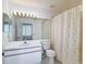 Bathroom featuring a large mirror, toilet, vanity, and shower with curtain at 6980 Ulmerton Rd # 7C, Largo, FL 33771