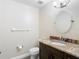 Bathroom featuring a vanity with granite countertop, oval mirror, toilet, and towel rack at 6980 Ulmerton Rd # 7C, Largo, FL 33771
