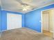 Bedroom with blue walls, a ceiling fan, carpet, and a closet with double doors at 6980 Ulmerton Rd # 7C, Largo, FL 33771