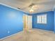 Bedroom with blue walls, carpet, ceiling fan, and window with shutters at 6980 Ulmerton Rd # 7C, Largo, FL 33771