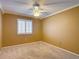 Bedroom featuring tan walls, carpet, a ceiling fan and a window with white shutters at 6980 Ulmerton Rd # 7C, Largo, FL 33771
