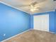 Bedroom with blue walls, a ceiling fan, carpet, and a closet with double doors at 6980 Ulmerton Rd # 7C, Largo, FL 33771