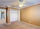 Neutral bedroom featuring a ceiling fan, closet, and carpeted floors at 6980 Ulmerton Rd # 7C, Largo, FL 33771