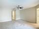 Spacious bedroom featuring neutral walls, carpet, ceiling fan and an open doorway to an adjacent room at 6980 Ulmerton Rd # 7C, Largo, FL 33771