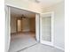 Open bonus room featuring carpet, sliding glass doors to a balcony, ceiling fan and access to other rooms at 6980 Ulmerton Rd # 7C, Largo, FL 33771