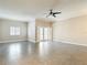 Large living room features a modern ceiling fan, tile floors, and double doors at 6980 Ulmerton Rd # 7C, Largo, FL 33771