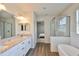 Bright bathroom featuring double vanities, granite countertops, tub, glass shower and tile floors at 7307 S Morton St, Tampa, FL 33616