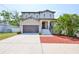 Charming two-story home featuring a two-car garage, well-maintained lawn, and inviting entryway at 7307 S Morton St, Tampa, FL 33616