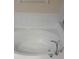 Close up of a white tub with a chrome faucet and spout, surrounded by white tile at 7504 Turtle View Dr, Ruskin, FL 33573