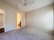 Neutral bedroom featuring carpet, ceiling fan, and ensuite bathroom view through the doorway at 7504 Turtle View Dr, Ruskin, FL 33573