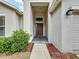 Inviting home entryway featuring a covered porch, neutral paint, and manicured landscaping at 7504 Turtle View Dr, Ruskin, FL 33573