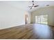 Bright, open living space with laminate floors, a ceiling fan, and sliding glass doors to the backyard at 7504 Turtle View Dr, Ruskin, FL 33573