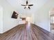 Open-concept living room featuring laminate floors, ceiling fan, and seamless flow to the kitchen area at 7504 Turtle View Dr, Ruskin, FL 33573