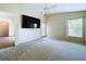 Spacious main bedroom with ceiling fan, tv, neutral carpet, and door to the outside, creating a serene retreat at 7504 Turtle View Dr, Ruskin, FL 33573