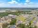 The property sits in a neighborhood near a pond, green space, and modern townhomes, all showcased in a wide aerial view at 7612 S 36Th Ave, Tampa, FL 33619