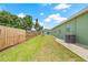 Spacious backyard featuring lush green grass, mature trees, and exterior of house at 7612 S 36Th Ave, Tampa, FL 33619