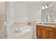 Well-lit bathroom featuring a glass shower, soaking tub, granite countertop vanity and wood cabinetry at 7612 S 36Th Ave, Tampa, FL 33619