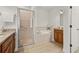 Well-lit bathroom featuring a glass shower, soaking tub, granite countertop vanity and wood cabinetry at 7612 S 36Th Ave, Tampa, FL 33619
