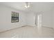 Bright bedroom featuring tile floors, a window, a ceiling fan, and access to a bathroom at 7612 S 36Th Ave, Tampa, FL 33619