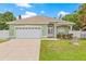 Charming single-story home featuring a well-manicured lawn, two car garage and lovely landscaping at 7612 S 36Th Ave, Tampa, FL 33619