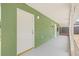 Covered patio area with an olive green painted wall, a white door, and concrete flooring at 7612 S 36Th Ave, Tampa, FL 33619