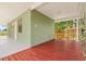 Outdoor patio with a red wooden deck and a green wall with white trim at 7612 S 36Th Ave, Tampa, FL 33619