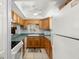 Traditional kitchen featuring wood cabinets, green countertops and white appliances at 7701 Starkey Rd # 332, Seminole, FL 33777