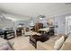 Living room featuring a sofa, accent chair, wood table, neutral tile floors and mirrored wall with view to kitchen at 7701 Starkey Rd # 332, Seminole, FL 33777