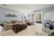 Bright living room featuring a sofa, wood table, neutral tile floors and access to screened in patio at 7701 Starkey Rd # 332, Seminole, FL 33777