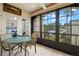 Relaxing patio with a small glass table, chairs, and view of the outdoors through large windows at 7701 Starkey Rd # 332, Seminole, FL 33777