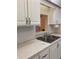 Kitchen sink area with white cabinets, a pass-through, and neutral-toned countertops at 7941 58Th N Ave # 106, St Petersburg, FL 33709