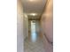 Hallway with tile floors, closet, and wallpaper, leading to the kitchen featuring neutral tones and natural light at 7941 58Th N Ave # 106, St Petersburg, FL 33709