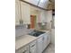 Kitchen featuring a stainless steel sink, white cabinets, and a pass-through to the dining area at 7941 58Th N Ave # 106, St Petersburg, FL 33709