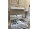 Gas range with white cabinets above and tile countertops at 7941 58Th N Ave # 106, St Petersburg, FL 33709